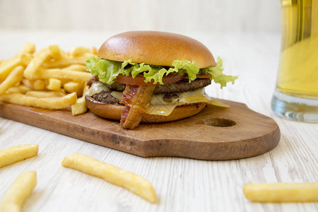 带生菜奶酪和培根的汉堡包在白色木制桌子上的铁制木图片