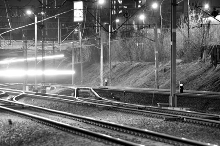 夜间火车轨上的客运列车模糊图片