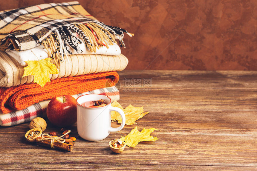 一杯热饮和一叠木头背景的编织衣服秋季概念复制空间选择焦点图片