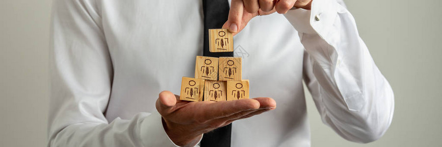商人用金字塔形的人物图标堆叠木图片