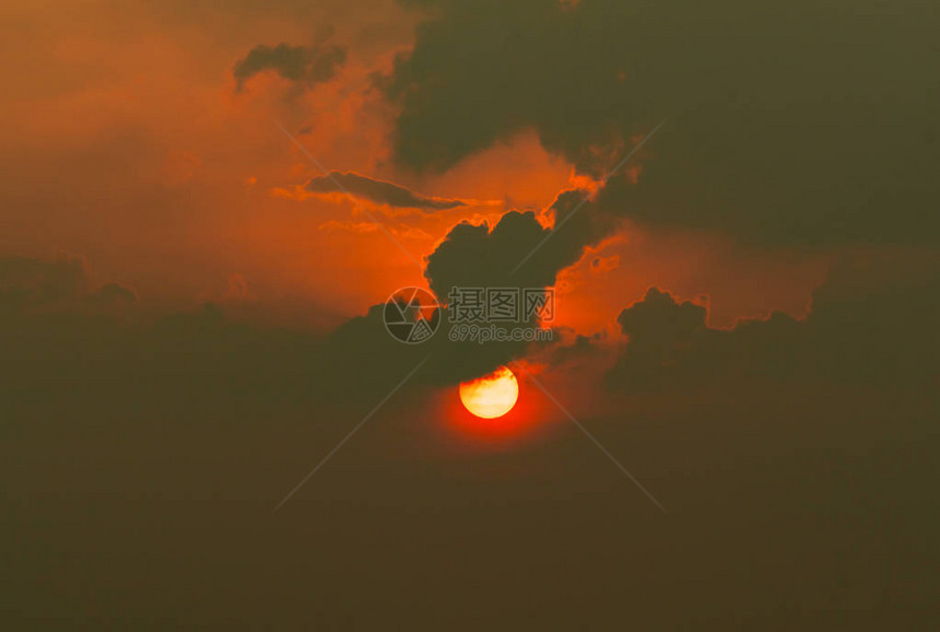 乌云中的红太阳夏日夕阳傍晚的太阳火辣的自然背景戏剧黑暗和红色的天空与日落天气炎热天堂的概念和平与宁图片