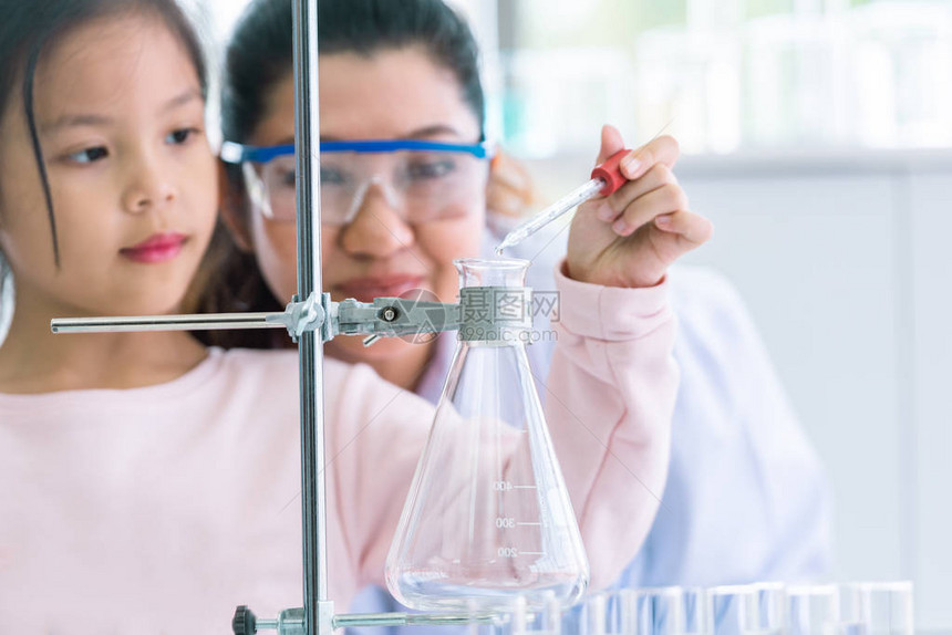 科学家女孩和老师一起用吸管将溶液物质液体滴入实验室教的试管中教育和科学微纳米技术电子保图片