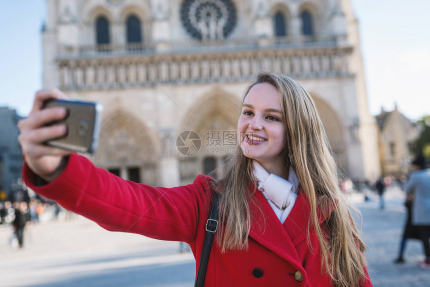 年轻的金发女郎在法国巴黎和圣母大教堂拍自她的背面是诺图片