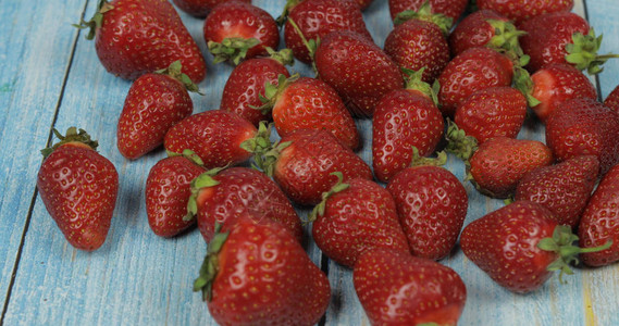 蓝木本底的草莓关闭新鲜成熟的红有机浆果您的标志图片