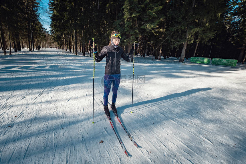 越野滑雪女子在白雪覆盖的森林小径上进行经典的北欧越野滑雪奥金佐沃莫斯科公园滑图片