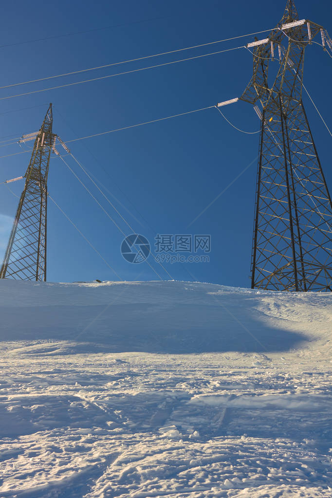 雪中电力晴天雪山顶电力缆塔冬季发展生态理念图片