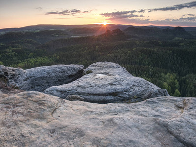 攀登山峰山峰和圆形森林高峰在岩石中间的阳光图片