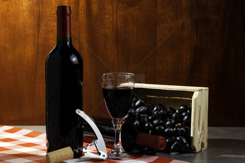 一瓶红酒在窖品尝红色木制背景与葡萄木盒葡萄酒传图片