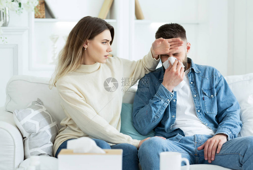 照顾生病丈夫的女人摸着他的额头图片