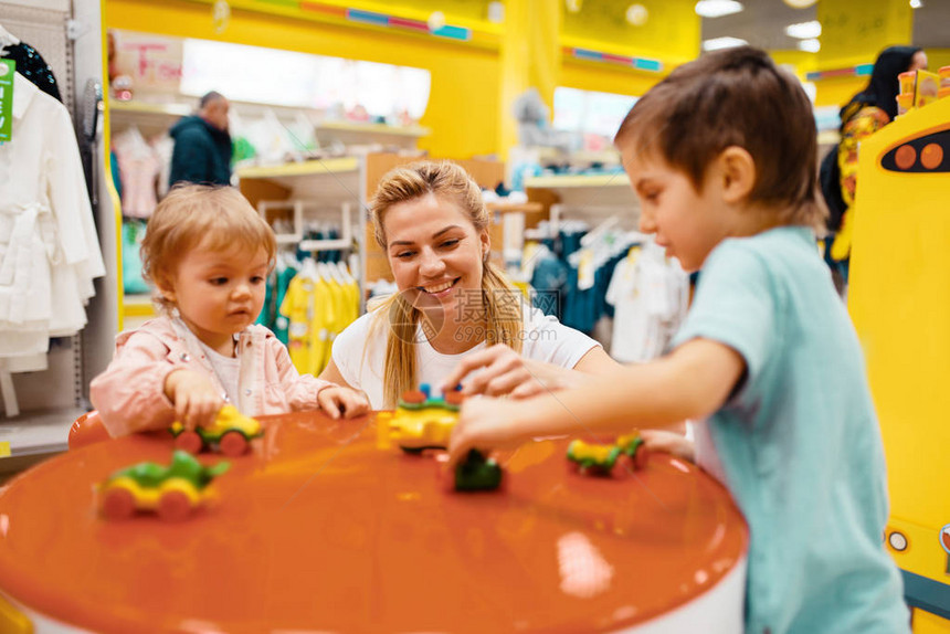 母亲带着她的小孩在儿童商店玩耍快乐的妈和女儿和子一起在超市买玩图片