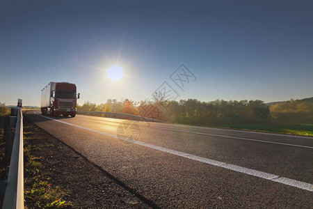 日落和货物在路上的卡车运输图片