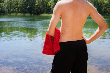 年轻健壮健壮的男子站在湖岸上图片