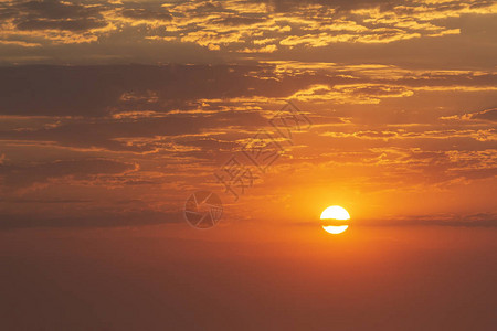 美丽的红日落暗云和地平线图片