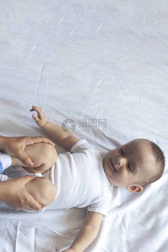 新生儿按摩妈和孩子一起做体操妈给她可爱的男婴按摩移动宝的腿图片