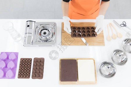 现代厨房里的女人准备制作几种形状的巧克力图片