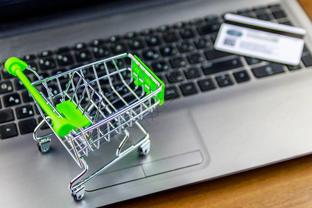 在线购物概念小型购物车和笔记本电脑键图片