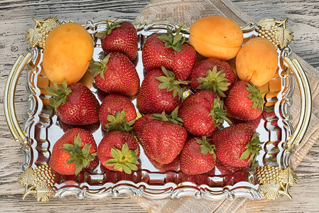 草莓和杏仁放在木制桌子的托盘上图片