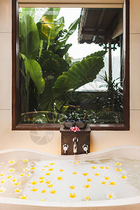 带有泡沫和黄色花朵的浴缸图片