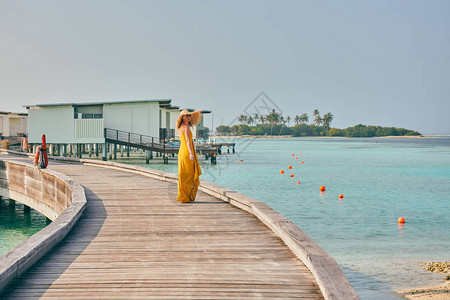 穿着衣服在热带沙滩上走着的女人在马图片