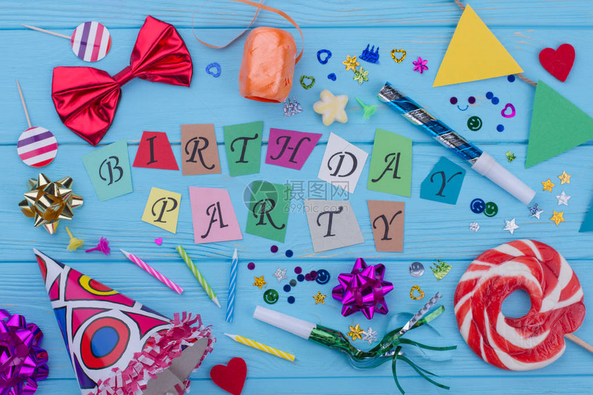 生日快乐背景与派对用品蓝色木制背景上的生日装饰生图片