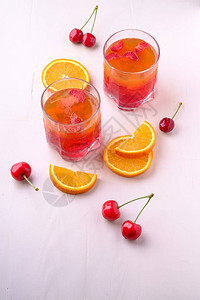 果冻甜点和草莓加饮料杯附近有樱桃浆图片