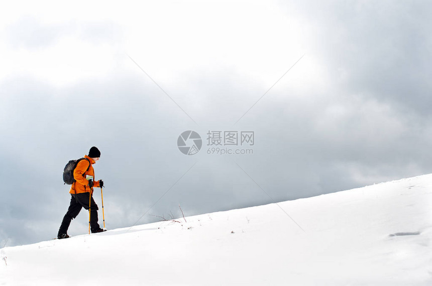 远足者在积雪的斜坡上升图片