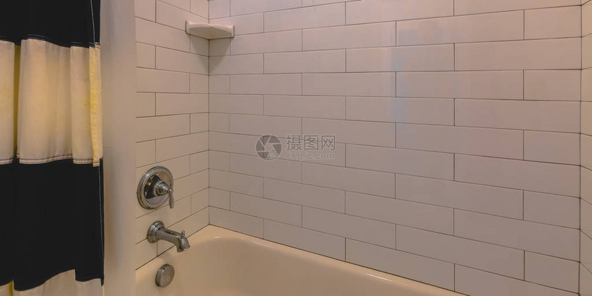 浴室配有浴缸和白色瓷砖墙图片