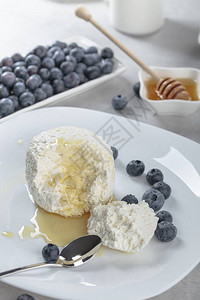 白盘上的蜂蜜和蓝莓奶酪图片