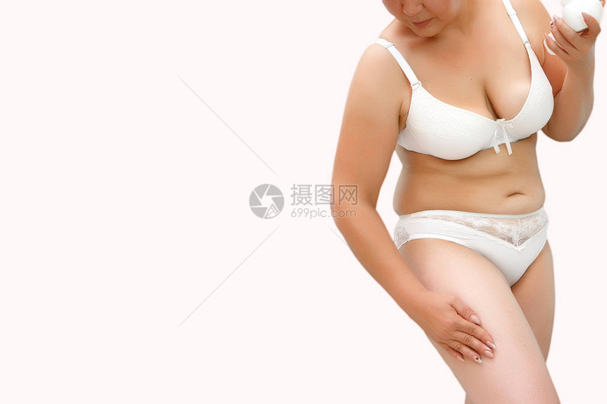 一个体重超的女人在臀部涂抹乳霜图片