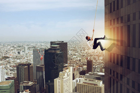 商人用绳子爬上高楼决心的概念图片