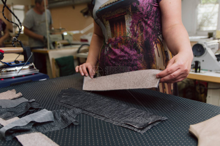 女人摸着织物做进一步缝纫用工业铁熨衣服图片