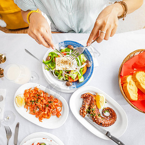 一个女人吃美味海鲜的特写镜头虾和章鱼烤和蔬菜沙拉地中海美食和健图片