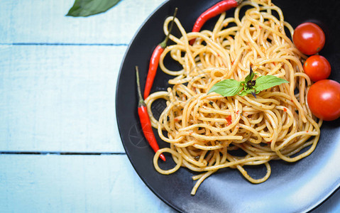意大利面番茄辣椒和罗勒叶蔬菜餐桌上盘子上的传统美味意大利图片