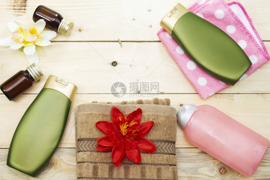 塑料瓶身体护理或洗发水和棕毛巾白底花分离的白花基本油图片