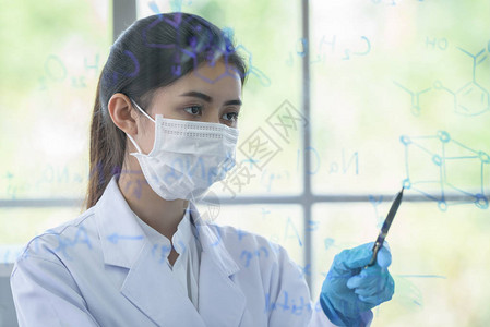 亚洲年轻女学生科学家在实验室写作和研究校图片