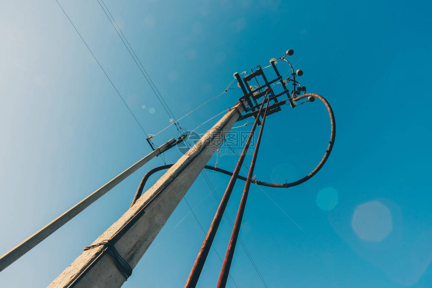 蓝天特写背景上的电源线电线杆上的电动轮毂具有复制空间的电力设备天空中的高压电图片