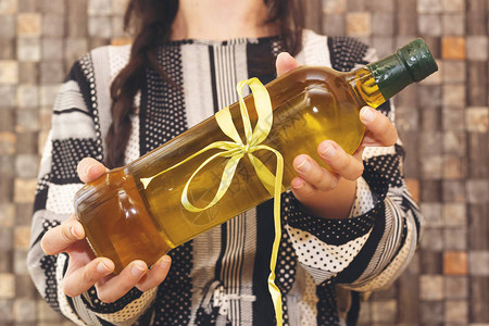 拿着纯橄榄油瓶礼物的女人图片
