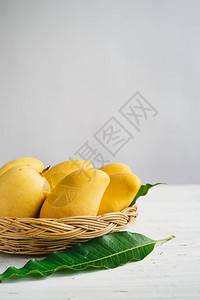 白色背景中篮子里的黄色芒果图片