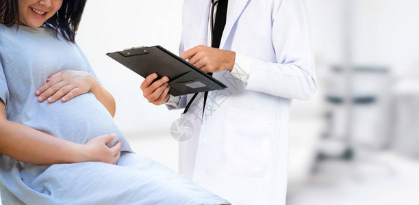 快乐的孕妇在医院或医疗诊所为怀孕顾问拜访妇科医生背景图片