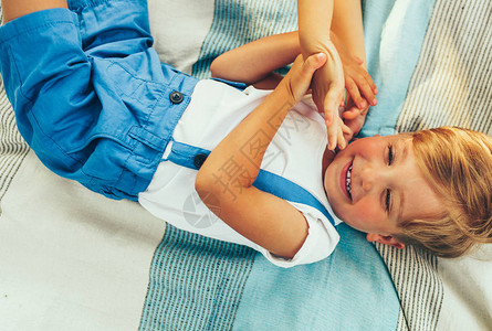 小男孩笑着躺在毯子上图片