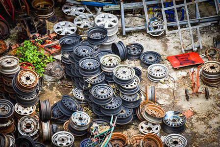 汽车垃圾中的一堆生锈的旧金属轮辋图片