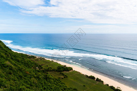 巴厘岛海景与巨大的海浪在美丽的隐藏的白色沙滩图片