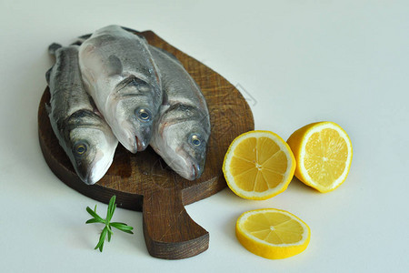 含柠檬和迷迭香的鲜鱼在木板上Fresh生鱼海贝海贝图片