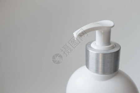 带分配器的乳液瓶用于护肤灰色背景上孤图片