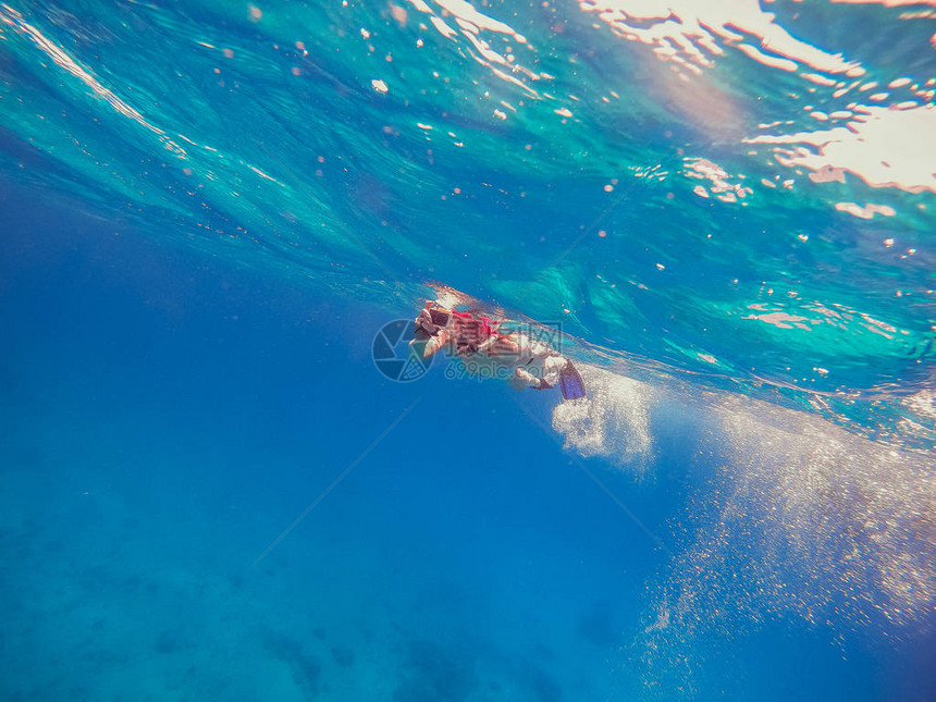 上下潜舞女孩带着一个动作相机在海上漂浮图片