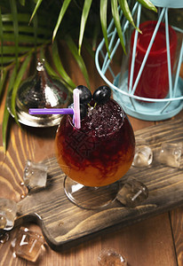 将红葡萄饮料刷新在玻璃杯中用木制背景的冰块加冰块图片