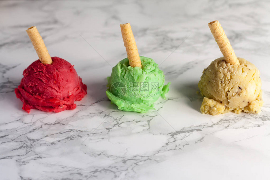 三颗绿色黄色和草莓色冰淇淋球图片