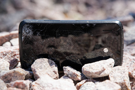 花岗岩石上断裂的智能手机玻璃图片