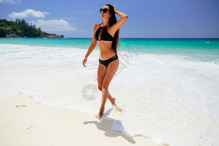 在热带海滩度假的女人海滩度假在热带海滩上穿着比基尼的热辣图片