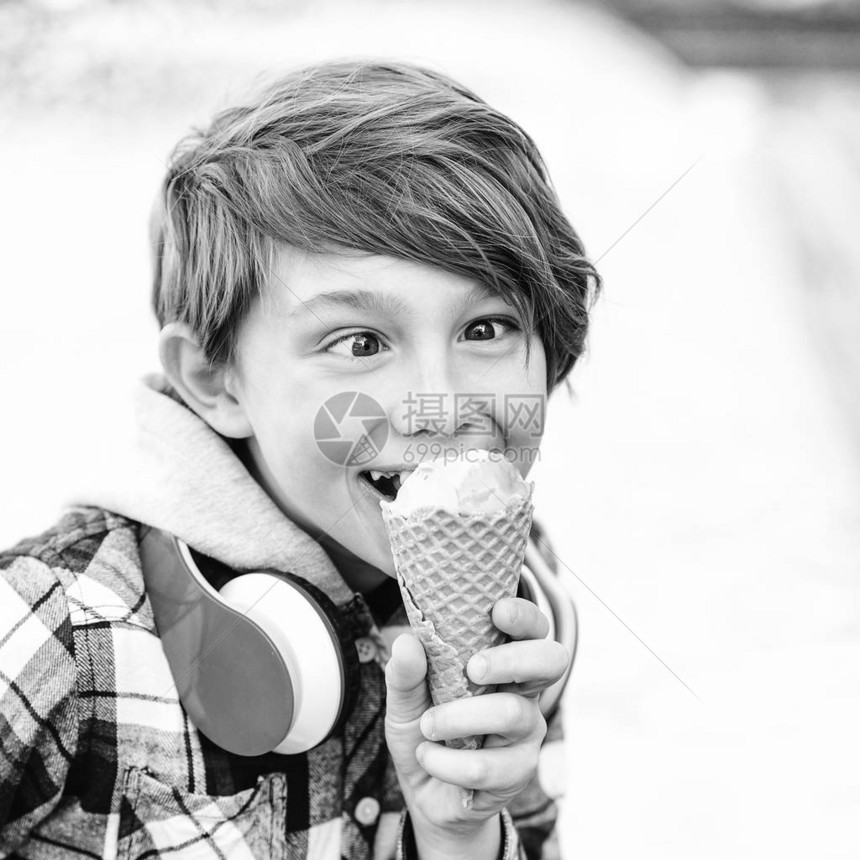 快乐的孩子吃冰淇淋可爱的男孩在华夫饼锥中拿着冰淇淋快图片